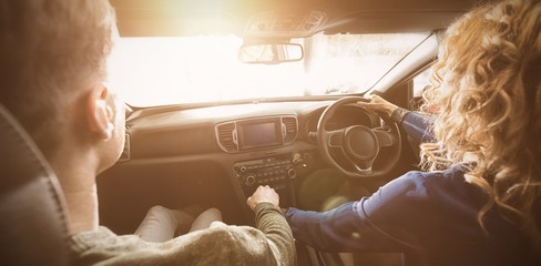 Poster - Woman driving while sitting with man in car