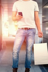 Poster - Composite image of low section of man holding shopping bag while