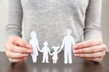 Poster - Woman holding paper silhouette of family, closeup. Insurance concept