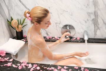 Canvas Print - Young beautiful woman relaxing in bath with foam