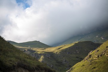  Горный пейзаж. Красивый вид на живописное ущелье, панорама горной местности, белые облака на синем небе. Природа и горы Северного Кавказа