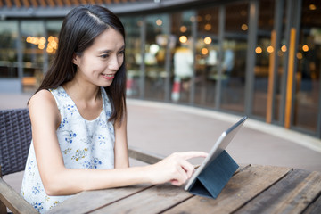 Wall Mural - Woman using tablet computer at outdoor coffee shop