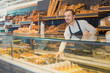 © JackF - Male shop assistant demonstrating fresh delicious pastry in bakery
