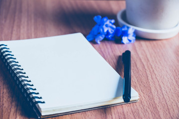 a sketchbook with a pen on the  brown wood  table floor for background