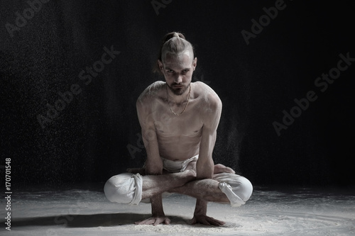 Fotografie, Obraz Young caucasian man yoga instructor doing Cock Pose Rooster Posture Kukkutasana