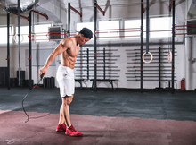 Muscular Man Skipping Exercise With Jumping Rope In Gym