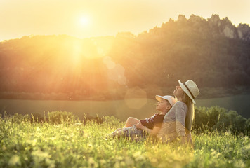 Happiness mother and son seating on the green grass around mount