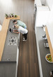 © Monkey Business - Overhead View Of Couple Looking At Laptop In Modern Kitchen