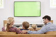 © Monkey Business - Rear View Of Family Sitting On Sofa In Lounge Watching Television