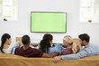© Monkey Business - Rear View Of Group Of Young Friends Watching Television Together