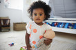 © Monkey Business - Portrait Of Baby Girl Playing With Doll In Playroom