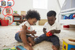 © Monkey Business - Baby Boy And Girl Playing With Toys In Playroom Together
