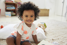 Portrait Of Happy Baby Girl Playing With Toys In Playroom