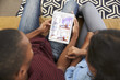 © Monkey Business - Couple Sitting On Sofa Looking At Home Improvement App