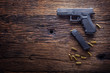 Gun pistol. 9 mm pistol gun and bullets strewn on the rustic oak table