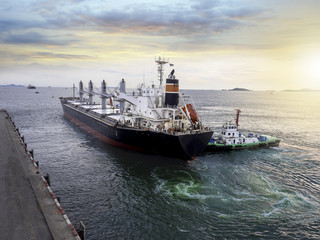 General cargo vessel during alongside at port of thailand and assist by tugs.