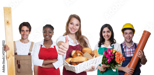 Tablou Canvas Erfolgreiche Bäckereiverkäuferin zeigt Daumen mit anderen Azubis