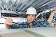 female electrician wiring in building ceiling