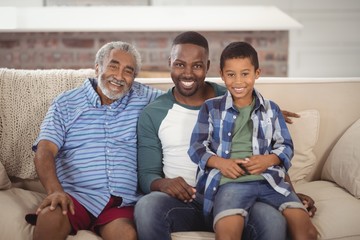 Wall Mural - Smiling multi-generation family sitting together on sofa