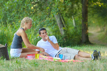 happy young couple on picnic blanket