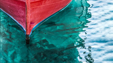 Tip Of A Red Fishing Boat In Clear Water