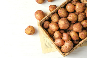 Sticker - Wicker basket with young potatoes on wooden table