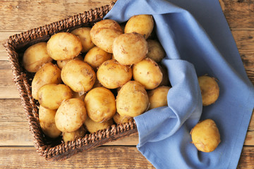 Sticker - Wicker basket with young potatoes on wooden table