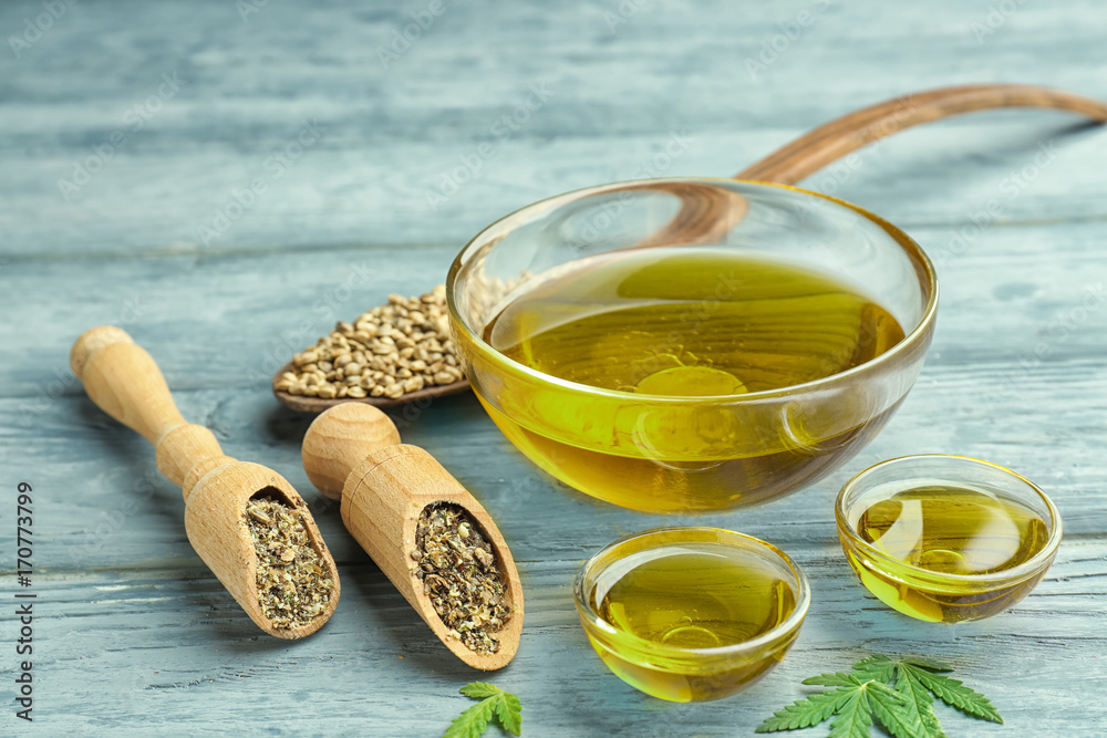 Composition with hemp oil and seeds on wooden background