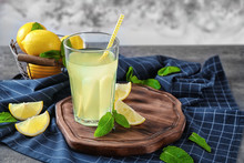 Composition With Glass Of Lemon Juice And Fresh Lemons On Table