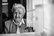 © De Visu - An elderly woman black and white portrait near the window.