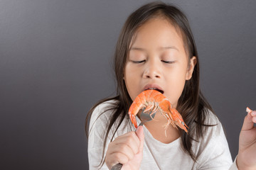 Asian children cute or kid girl eating shrimp