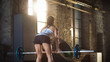 © Gorodenkoff - Back View of a Strong Athletic Woman Lifting Barbell as Part of Her Cross Fitness Bodybuilding Gym Exercise.
