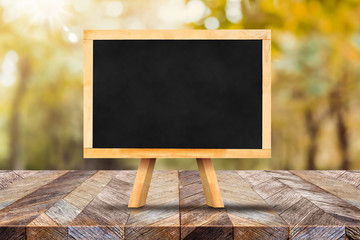 Aufkleber - Blackboard on wood table top with blur autumn forest,Autumn background,Mock up for display or montage of product,banner for advertise on online