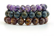 Close up Charoid , Pietersite and Cacoxenite beads in bracelets on white background