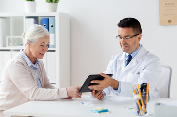 Poster - senior woman and doctor with tablet pc at hospital