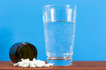 Poster - Glass bottle for pills on a brown wood table. Beautiful brown background. 