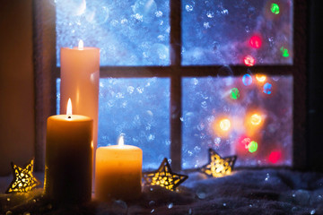 Wall Mural - winter decoration with candles near the snow-covered window