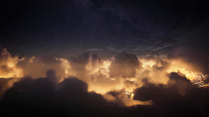 Wall Mural - flying over the deep night clouds with dark sky. flight through moving cloudscape over night city li