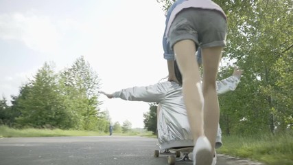 Wall Mural - Two female friends having fun riding on longboard together