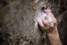 Closeup Of Rock Climber's Hand Gripping Hold