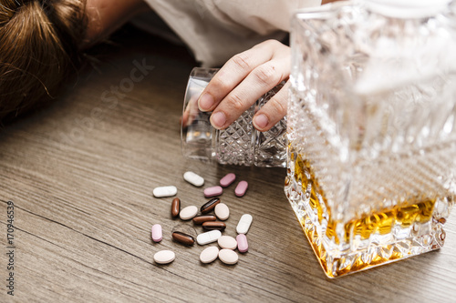 Plakat pijana lub zatruta młoda kobieta z butelką alkoholu i tabletek