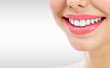 © Nobilior - Closeup shot of young smiling woman, grey background, copyspace. Part of face
