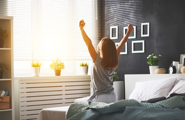 young woman woke up in the morning in the bedroom by the window with her back