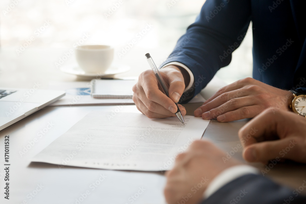 Close up image of businessman hand putting personal signature on contract document in presence of business partner. Starting successful partnership with entrepreneur or companie, making good deal - obrazy, fototapety, plakaty 