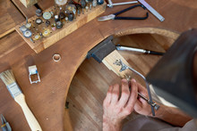 High Angle Closeup Of Jeweler Making Flower Ring In Workshop, Forming  It On Work Station With Different Tools