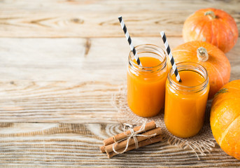 Wall Mural - Pumpkins juice in bottle with pumpkins and cinnamon