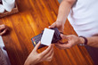 © baranq - Top view of female hand holding credit card paying with wooden counter in background