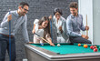 © Bojan - Business people playing billiard after work.