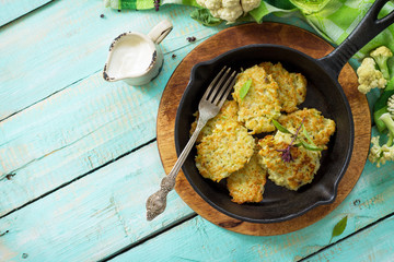 Vegetable pancakes. Fried vegetarian cutlets or fritters on a kitchen wooden table. The concept of dietary nutrition. Top view with copy space.