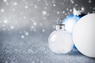 Wall Mural - blue, silver and white christmas ornaments on glitter holiday background with blurred snow. merry ch
